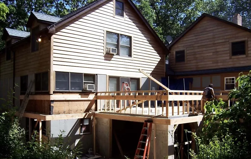 Deck framing in progress behind a house