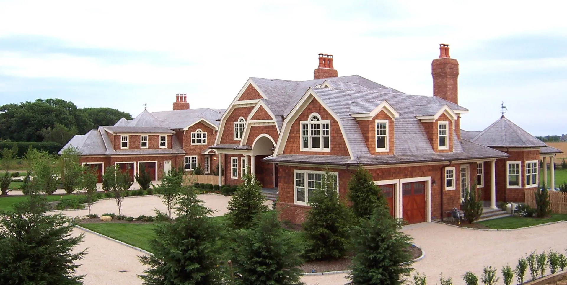 Brick and shingle estate with an attached garage and circular drive