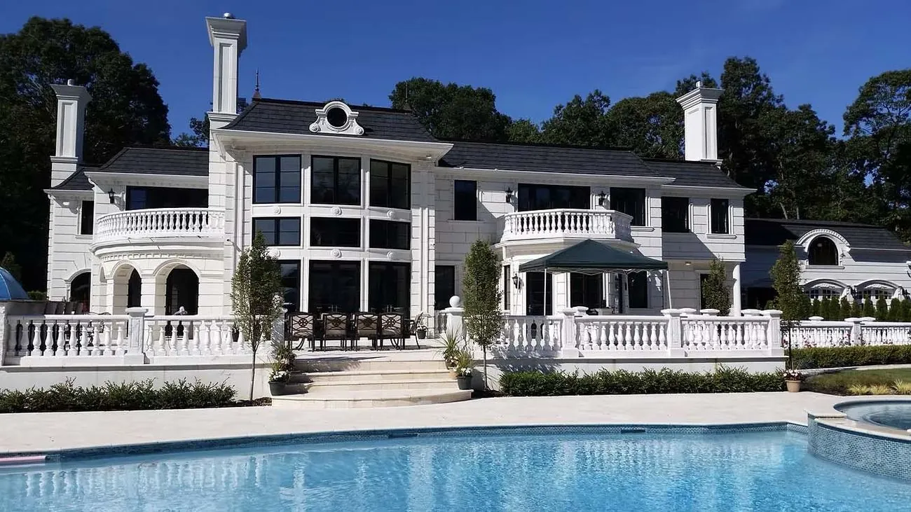 White home rear elevation with terrace and pool