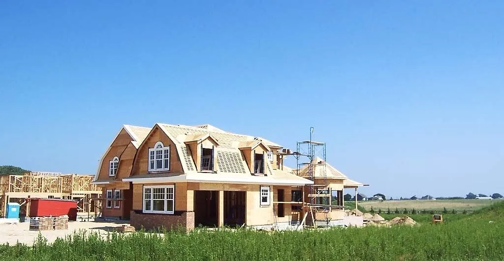 The same home during framing, under a blue sky
