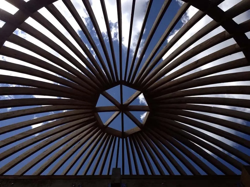 Radial roof rafters viewed from below against the sky