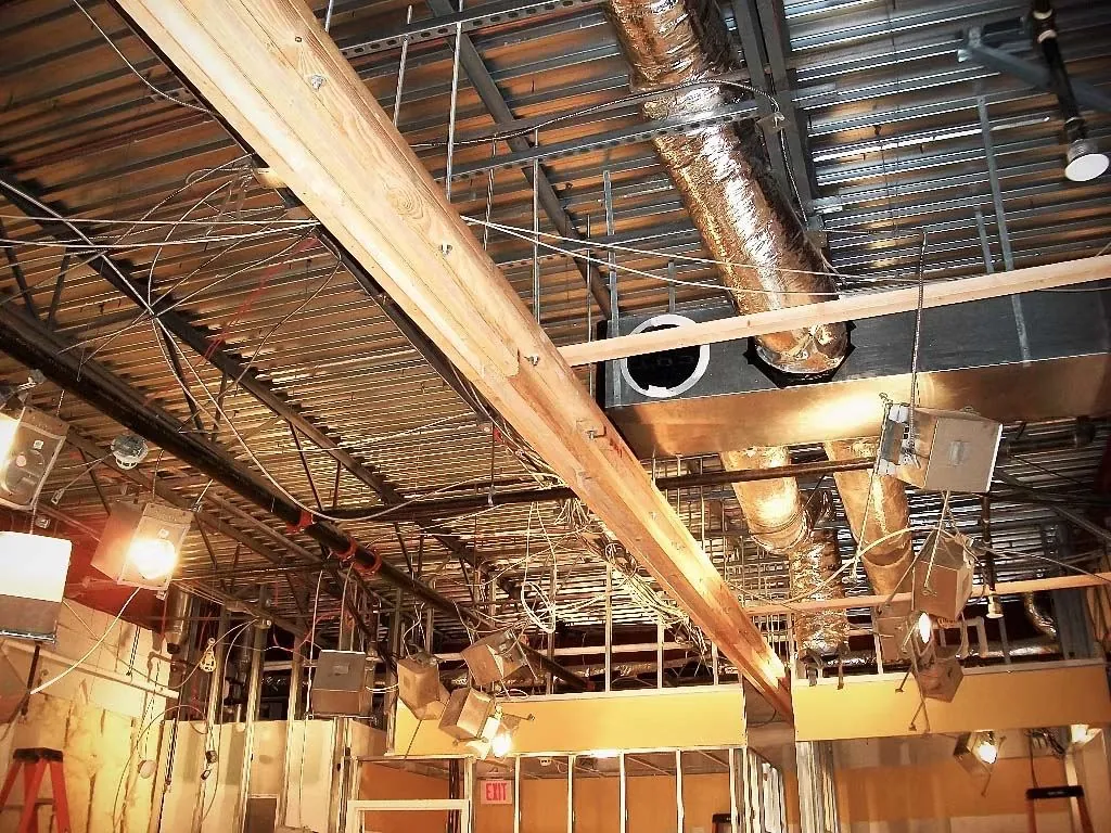 Exposed ceiling with ductwork and wiring during a renovation