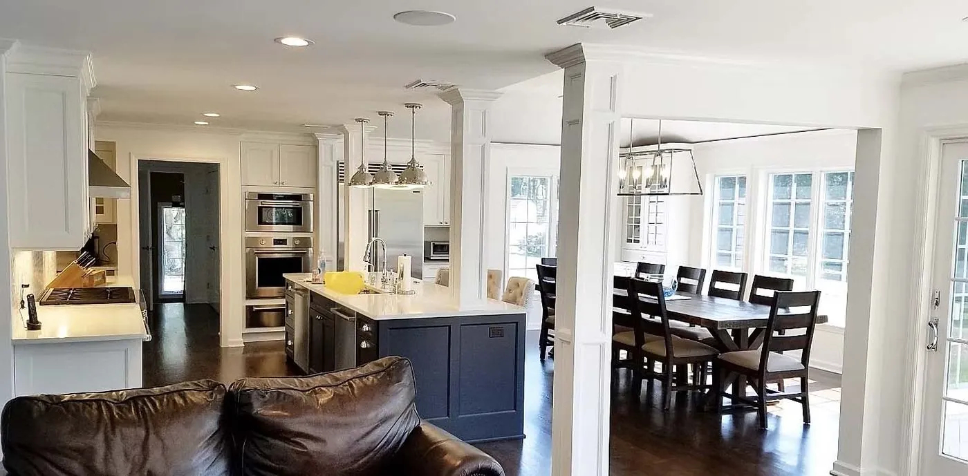 Kitchen with white cabinetry, island, and dark hardwood floors