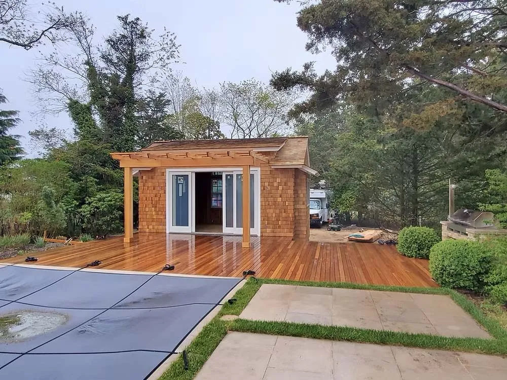Backyard studio with pergola, deck, and covered pool
